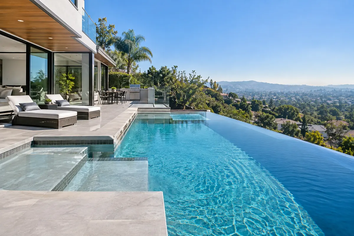 Infinity edge pool with a sun shelf overlooking a valley view